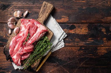 Çiğ kemiksiz kuzu eti, tahta tahtada çiğ boyun eti. Siyah arka plan. Üst Manzara. Boşluğu kopyala