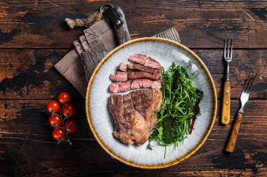 Barbekü kızarmış Chuck Roll bifteği ve tabakta salata. Ahşap arka plan. Üst görünüm