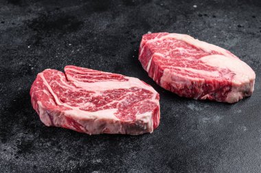 Çiğ Chuck göz devirme bifteği, kasap tahtasındaki kıymalı et. Siyah arka plan. Üst görünüm