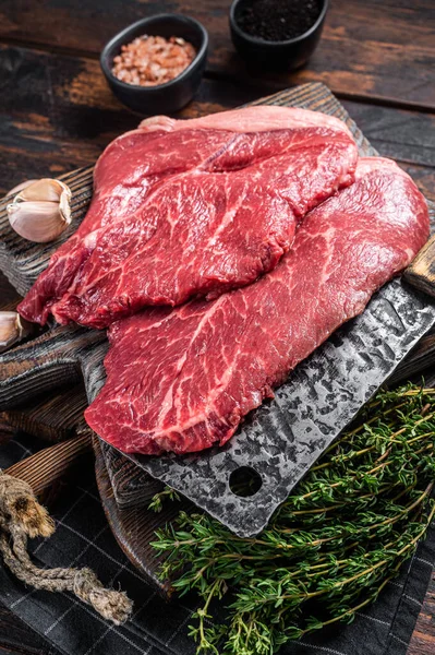 プライムビーフの仔牛ステーキ、肉屋のまな板にスパイスのある生肉。木製の背景。トップ表示 — ストック写真