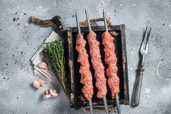 什锦烤肉来自生肉羊肉和牛肉肉，土耳其式的阿达纳烤肉。灰色背景。顶部视图 — 图库照片