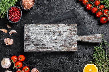 Pişirme malzemeleri ve eski ahşap masa üzerindeki boş kesim tahtası yemek pişirme ve sağlıklı beslenme arka planı. Siyah arka plan. Üst Manzara. Boşluğu kopyala
