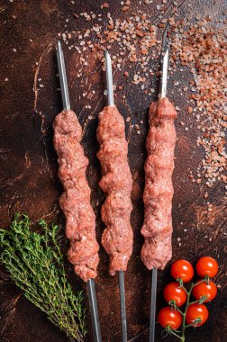 Çiğ kıymalı kuzu kıymalı şiş kebap ve şiş kebap. Ahşap arka plan. Üst görünüm