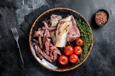 Kırsal tabakta füme sığır eti ve ızgara pirzola. Siyah arka plan. Üst görünüm