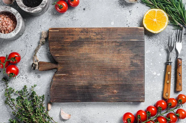 Voedsel koken en gezond eten achtergrond met houten snijplank en verse kruiden, kruiden en groenten. Grijze achtergrond. Bovenaanzicht. Kopieerruimte — Stockfoto