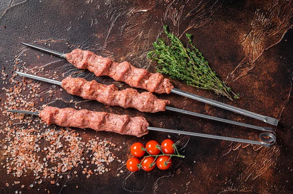 Çiğ kıymalı kuzu kıymalı şiş kebap ve şiş kebap. Ahşap arka plan. Üst görünüm