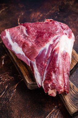 Kasap masasında çiğ koyun budu. Karanlık arka plan. Üst görünüm