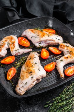 Tavada kekik ile kavrulmuş tavşan bacağı. Siyah arka plan. Üst görünüm