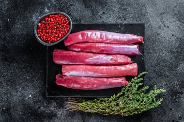 Taze çiğ kuzu fileto fileto, mermer tahtada koyun filetosu kekik. Siyah arka plan. Üst görünüm