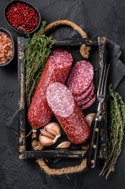 Dilimlenmiş salam sosisi ve taze kekik. Siyah arka plan. Üst görünüm