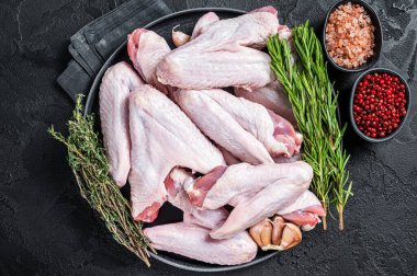 Çiğ ördek kanatları ve şifalı otlar. Siyah arka plan. Üst görünüm