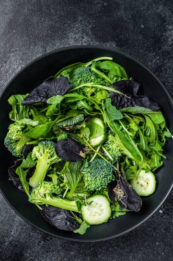 Ispanak, roka yaprağı, pazı ve sebzeli kuzu marulu taze salata karışımı. Siyah arka plan. Üst görünüm