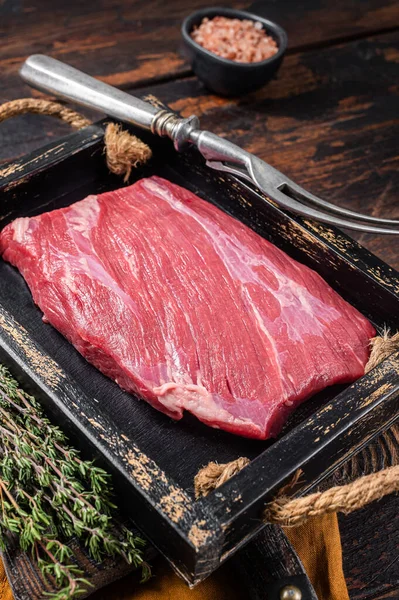 Grass Fed rohes Rindfleischsteak in Holzschale mit Kräutern. Holzuntergrund. Ansicht von oben — Stockfoto