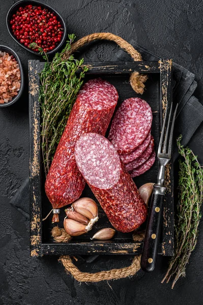 Dilimlenmiş salam sosisi ve taze kekik. Siyah arka plan. Üst görünüm