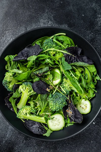 Ispanak, roka yaprağı, pazı ve sebzeli kuzu marulu taze salata karışımı. Siyah arka plan. Üst görünüm