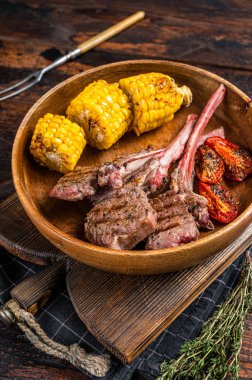 Barbekü kuzu pirzolası, kuzu eti ve ahşap tabakta koyun eti. Koyu ahşap arka plan. Üst görünüm