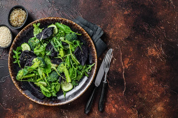 Gesunder Gemüsesalat mit frischen Blättern von Rucola, Salat, Spinat für veganen Salat. Dunkler Hintergrund. Ansicht von oben. Kopierraum — Stockfoto