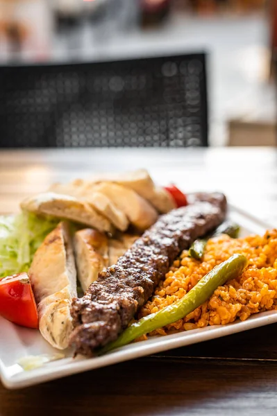 Traditional Turkish Adana kebab or kebap meat food with marinated peppers, bread and rice pilaf. Top view — Stock Photo, Image