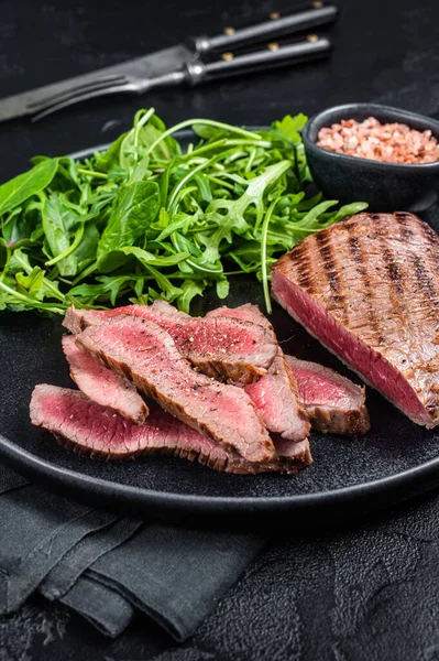 BBQ grilované sukně Steak na talíři se zeleným salátem. Černé pozadí. Horní pohled — Stock fotografie