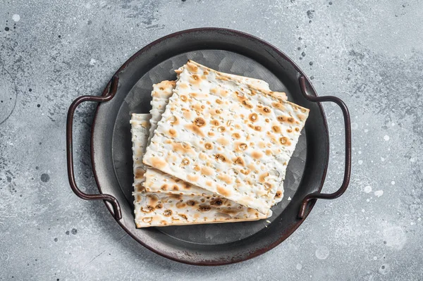 Pezzi di matzah in un vassoio d'acciaio vintage. Sfondo grigio. Vista dall'alto — Foto Stock