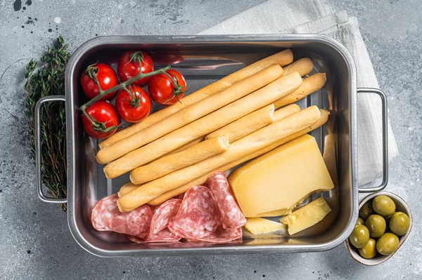 Appetizer schotel met grissini brood sticks, salami, tomaat en parmezaanse kaas. Gray bakground. Bovenaanzicht — Stockfoto