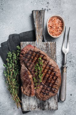 Biberiye ve kekik ile ızgara sığır filetosu bifteğinde kızartılmış. Gri arka plan. Üst görünüm