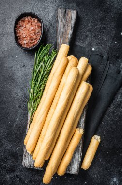 İtalyan Grissini ya da tahta tahtada tuzlu ekmek çubukları. Siyah fırın. Üst görünüm