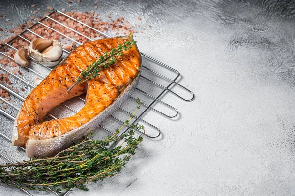 Barbecue Salmone alla griglia Bistecca di pesce su una griglia con timo e sale rosa. Sfondo bianco. Vista dall'alto. Copia spazio — Foto Stock