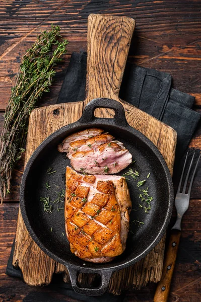 Pato de pechuga asado en una sartén, filete de carne de ave con hierbas. Fondo de madera. Vista superior —  Fotos de Stock