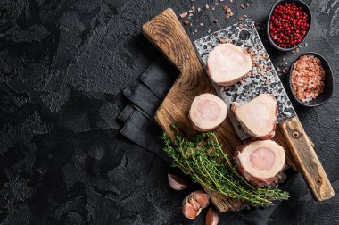 Et satırıyla kasap panosunda pişmemiş çiğ kemik. Siyah arka plan. Üst Manzara. Boşluğu kopyala