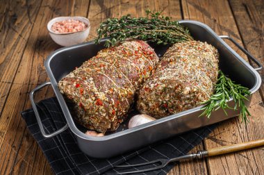 Çiğ domuz eti, italyan Porchetta otlar ve baharatlarla. Ahşap arka plan. Üst görünüm