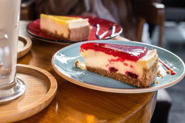 Klasik New York çileği ve limonlu cheesecake, kafede ahşap bir masada. Üst görünüm
