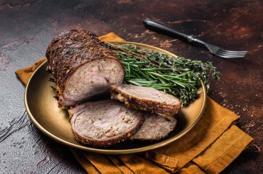 Biberiye ve kekikli bir tabakta kızarmış domuz eti lapası. Karanlık arka plan. Üst görünüm