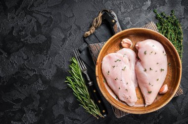 Dilimlenmiş çiğ tavuk göğsü fileto, tavuklu biftekler tabakta. Siyah arka plan. Üst Manzara. Boşluğu kopyala