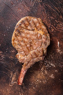 Kemik baltasında biftek, kaburga. Karanlık arka plan. Üst Manzara. Boşluğu kopyala