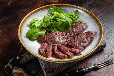 Izgara Flap bifteği ve mangalda pala bifteği ve otlarla birlikte. Gri arka plan. Üst görünüm.