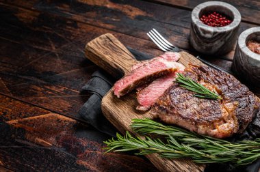 Dilimlenmiş ve ızgara pirzola bifteği, ahşap bir tahtanın üzerinde kaburga eti. Ahşap arka plan. Üst Manzara. Boşluğu kopyala.