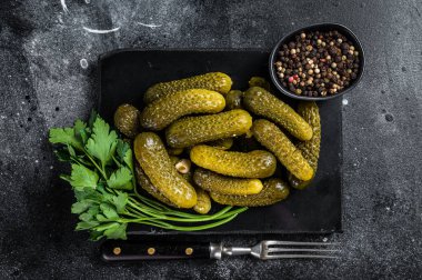 Sarımsak ve baharatlı salatalık turşusu. Siyah arka plan. Üst görünüm.