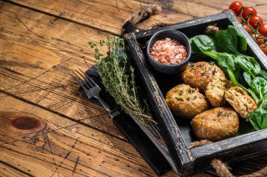 Seafood Fish balls or Fish cake with spinach and herbs in a tray. Wooden background. Top view. Copy space.