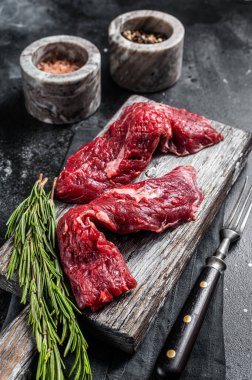 Kanat bifteği çiğ kesilmiş ve tahta tahtada Machete bifteği. Siyah arka plan. Üst görünüm.