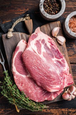 Tahta tahtada çiğ et ve şifalı bitkilerden yapılmış çiğ domuz eti. Ahşap arka plan. Üst görünüm.