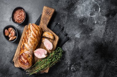 BBQ kızarmış domuz filetosu ahşap tahtada otlarla birlikte fileto. Siyah arka plan. Üst Manzara. Boşluğu kopyala.