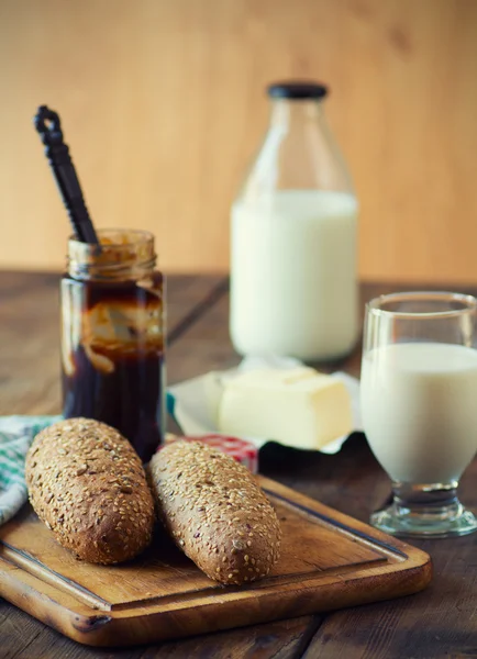 Pane integrale con un bicchiere di latte sul tavolo di legno — Foto Stock
