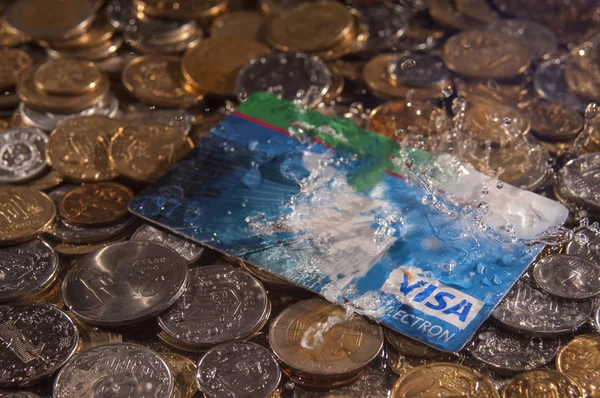 Creditcard op een stapel van munten in de regen Stockfoto