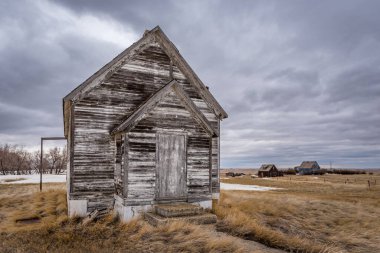 Battrum, Saskatchewan yakınlarındaki bozkırlarda terk edilmiş iki evi olan terk edilmiş bir okul binasının dış cephesi.