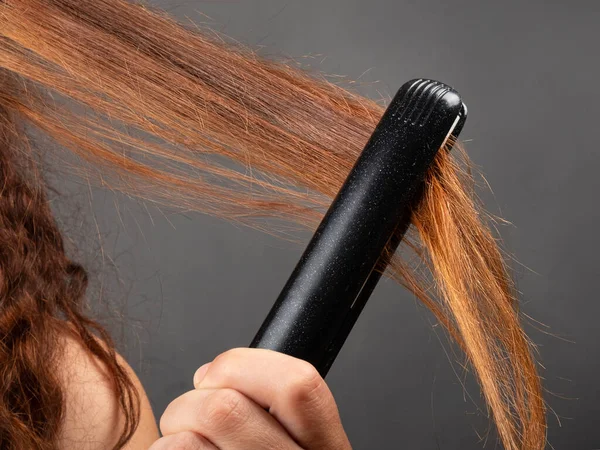 Haar rechttrekken met een strijkijzer, haarverzorging. — Stockfoto