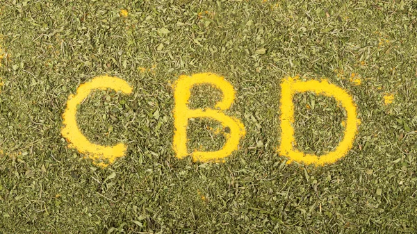 La palabra cbd en hojas de cannabis verde seco, signo medicinal de la marihuana — Foto de Stock