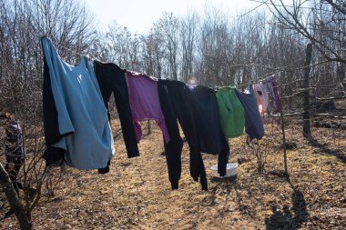 Çamaşırlar ve giysiler bahçede asılı..