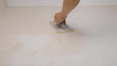 Usta sıva duvarları zımpara kağıdıyla elle ovuyor. Yüksek kaliteli FullHD görüntüler