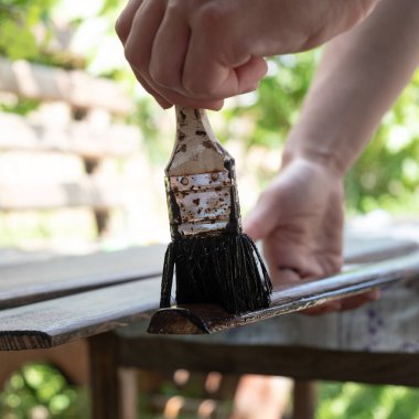 Ressam ahşap mobilya elementlerini boyar, ahşabı fırçayla parlatır..